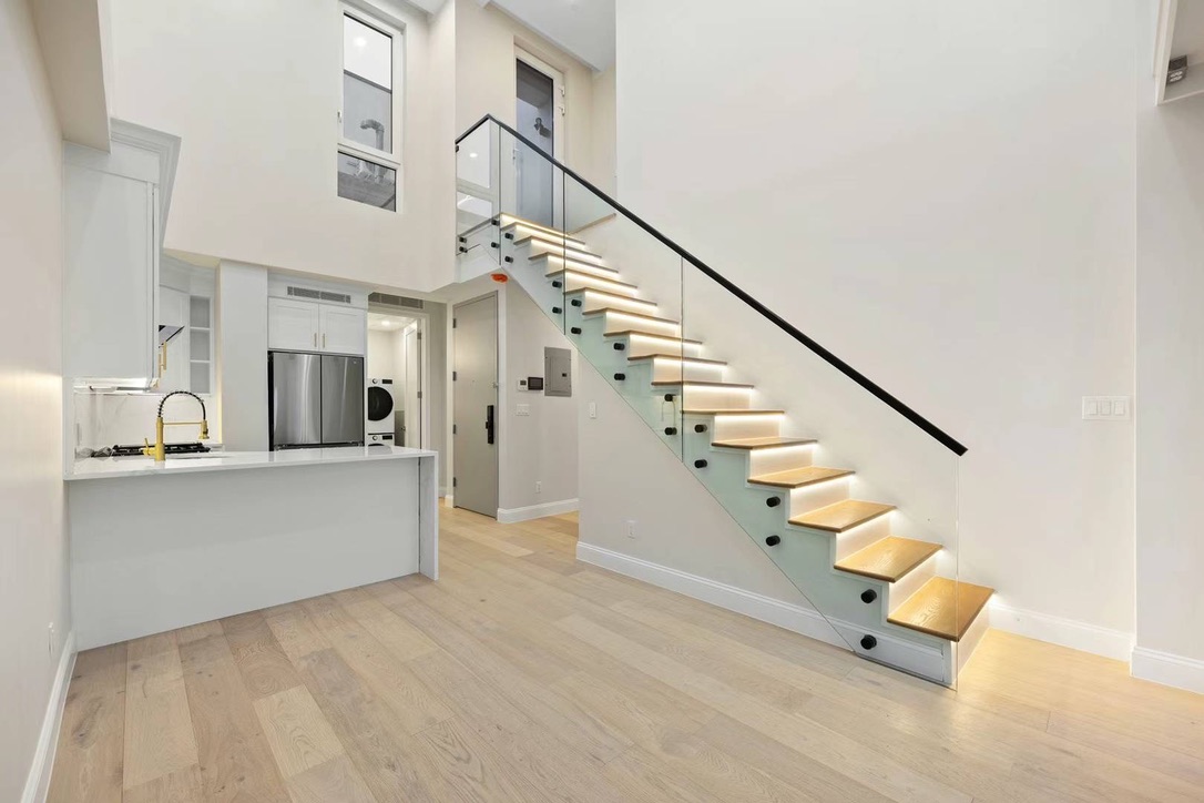 Duplex interior with illuminated staircase and open kitchen at Hampton Condo